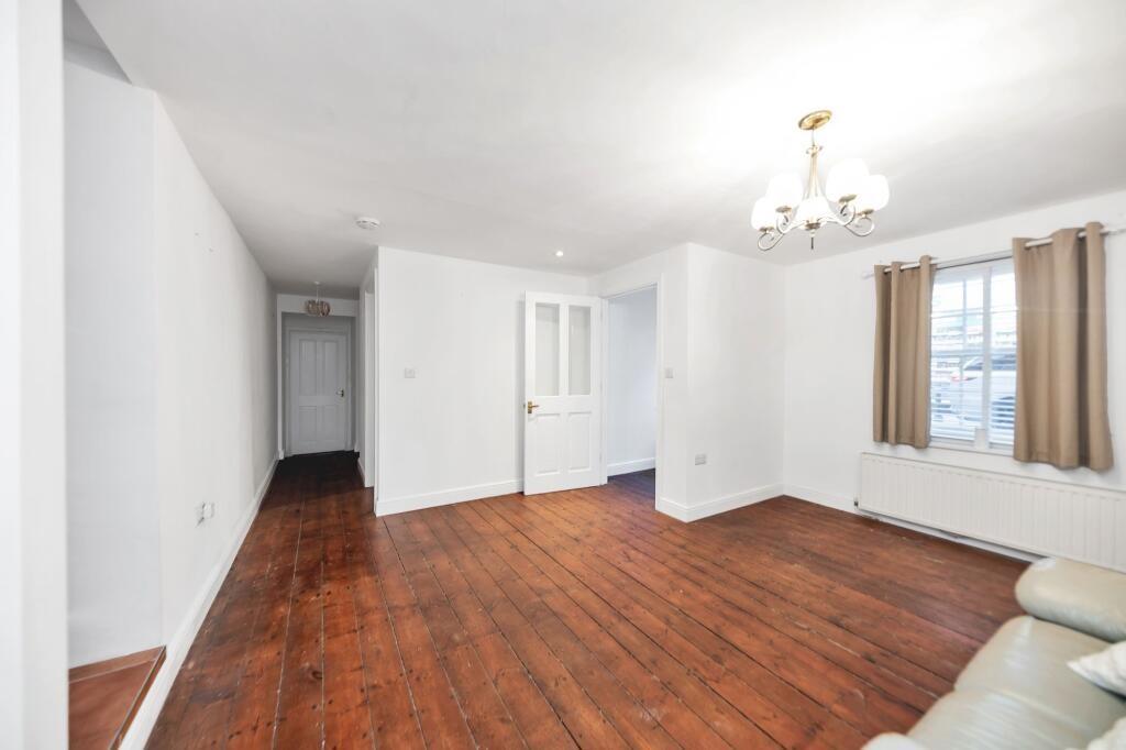 Lot: 79 - GROUND FLOOR FLAT SITUATED ON HIGH STREET - Living room showing window and hallway